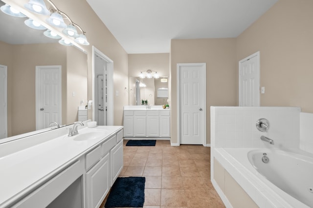 bathroom featuring tile patterned floors, two vanities, a bath, and a sink