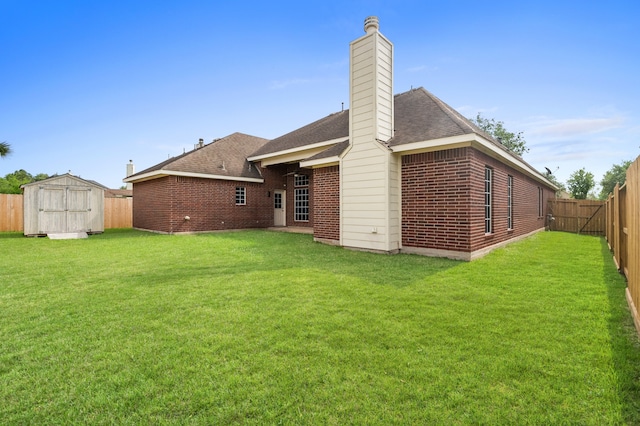 rear view of house featuring a chimney, a storage shed, a lawn, brick siding, and a fenced backyard
