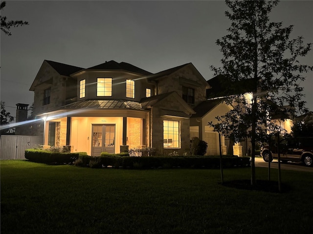 7526 Janak Dr, Houston, TX 77055 - back of house at twilight with a standing seam roof, stone siding, and metal roof