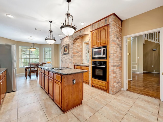 kitchen featuring a kitchen island, light tile patterned flooring, visible vents, black appliances, and brown cabinets
