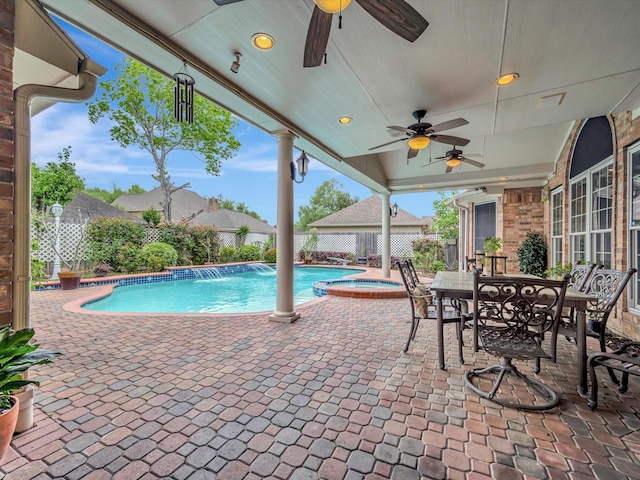 view of pool with a pool with connected hot tub, a patio area, a ceiling fan, a fenced backyard, and outdoor dining space