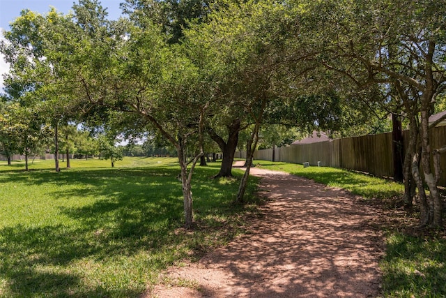 view of property's community featuring fence and a yard