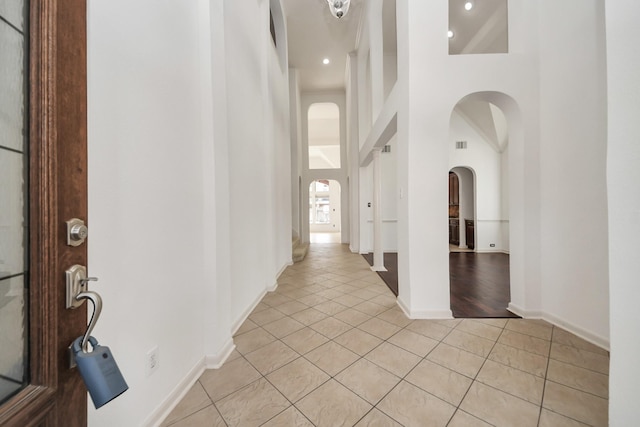6423 Middlelake Ct, Katy, TX 77450 - hallway with arched walkways, light tile patterned floors, a high ceiling, baseboards, and recessed lighting