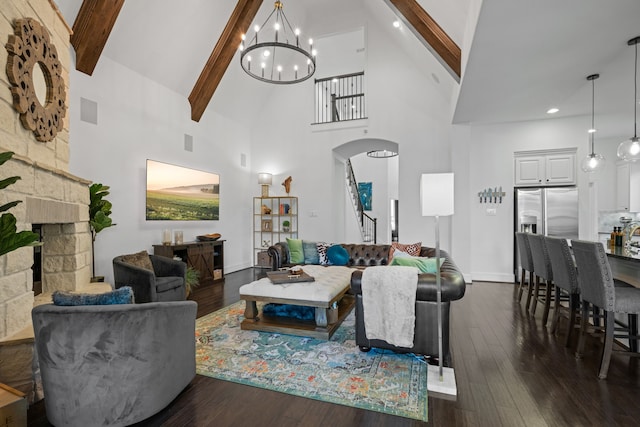19843 Quarry Stone Ln, Richmond, TX 77407 - living room with arched walkways, high vaulted ceiling, a chandelier, a stone fireplace, and beamed ceiling