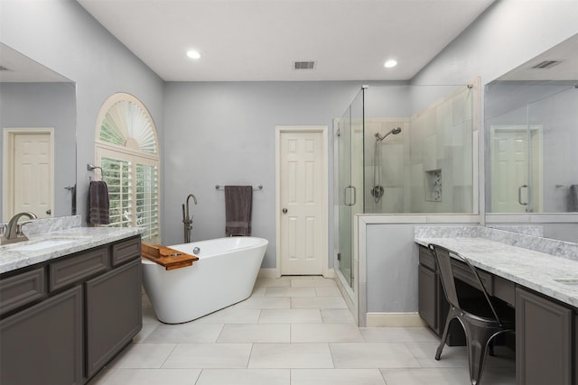 full bathroom featuring a sink, a soaking tub, a shower stall, and two vanities