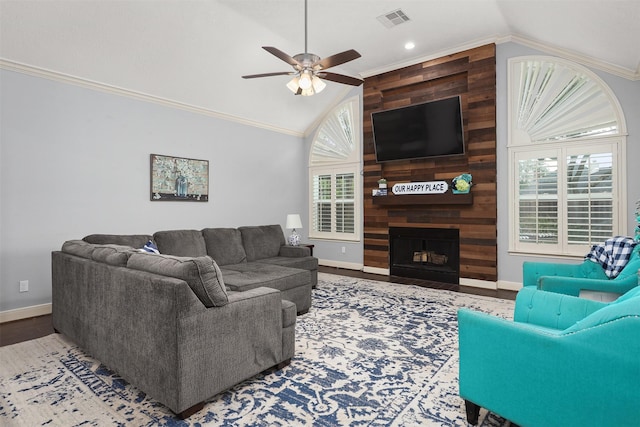 living room with vaulted ceiling, crown molding, a ceiling fan, plenty of natural light, and visible vents