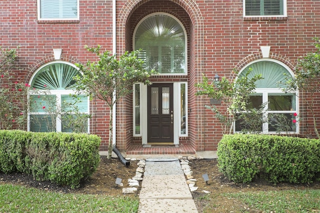 view of exterior entry with brick siding