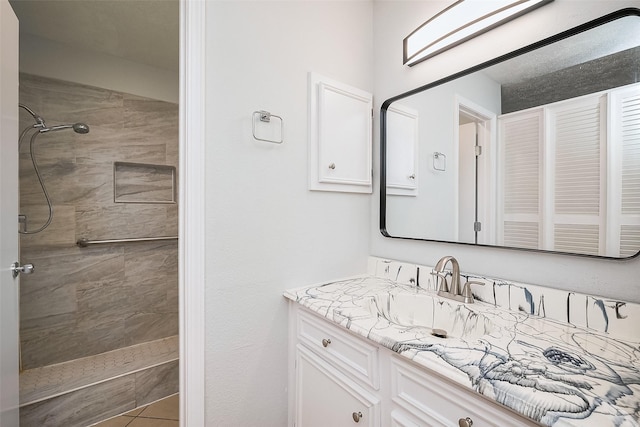 bathroom with vanity and tiled shower