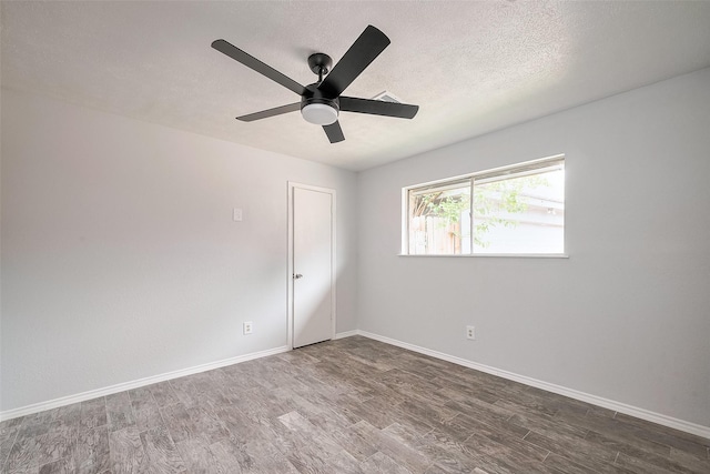 spare room featuring a ceiling fan, a textured ceiling, baseboards, and wood finished floors
