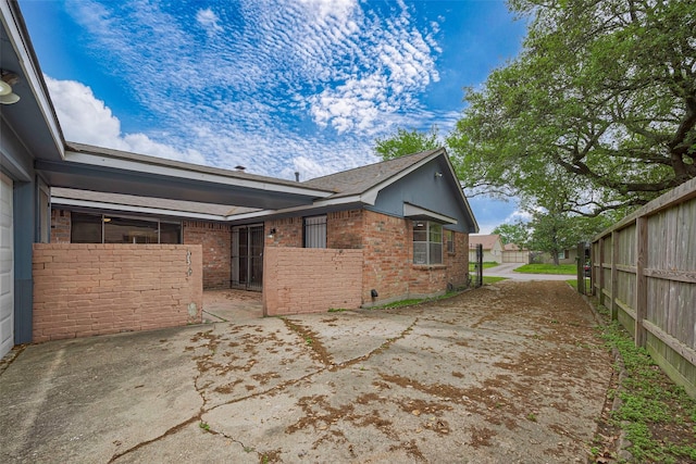 view of home's exterior with a patio area, fence, and brick siding