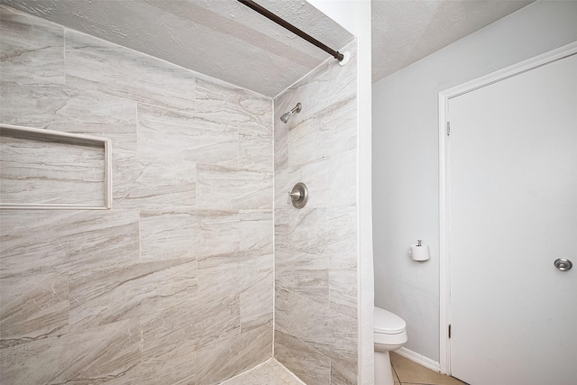 full bath featuring toilet, a tile shower, and a textured ceiling