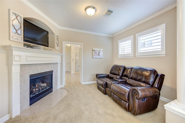 living room with ornamental molding, a tiled fireplace, carpet flooring, and baseboards