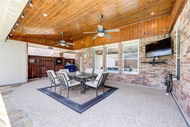 view of patio with a ceiling fan, fence, and outdoor dining space
