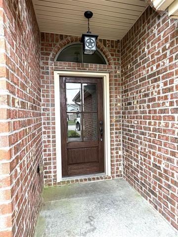 property entrance featuring brick siding