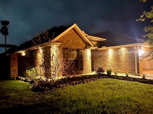 view of front of property featuring stone siding and a yard