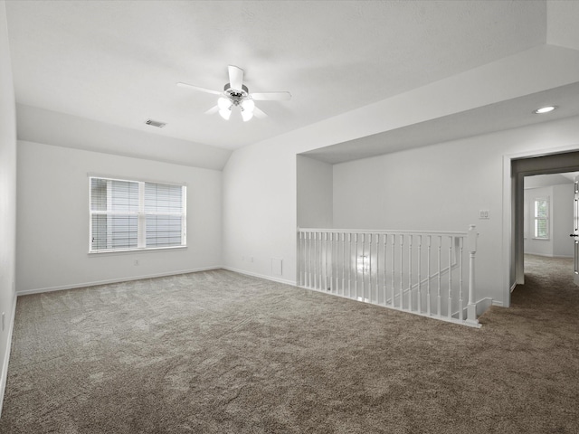 unfurnished room with visible vents, baseboards, a ceiling fan, carpet floors, and vaulted ceiling