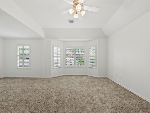 unfurnished room with vaulted ceiling, carpet, baseboards, visible vents, and ceiling fan