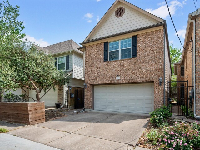 view of front of home featuring driveway, brick siding, and an attached garage