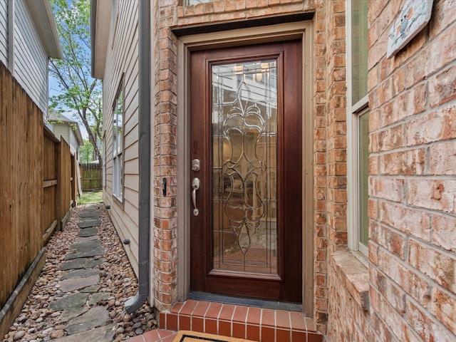 view of exterior entry featuring fence