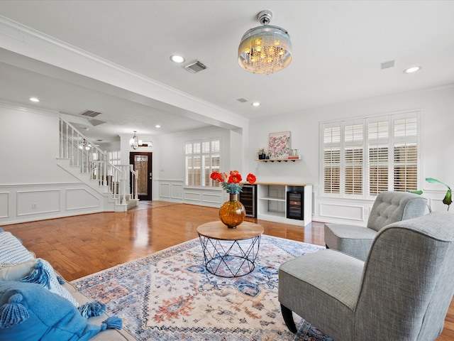 living room with stairs, a decorative wall, a chandelier, and visible vents