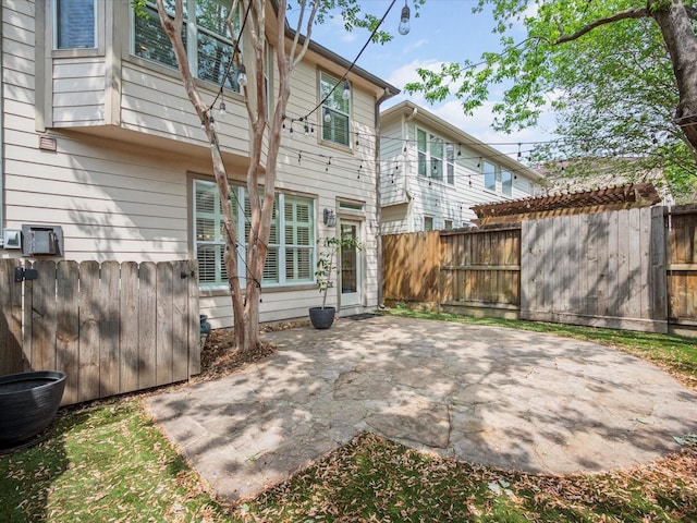back of property with a fenced backyard and a patio area