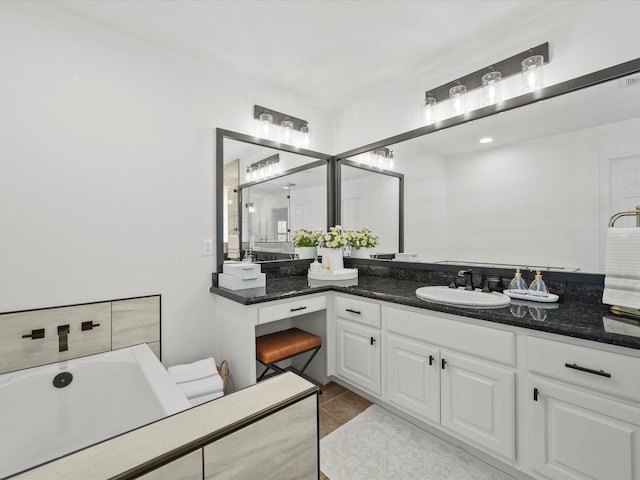 bathroom featuring tile patterned flooring, a bathtub, and vanity