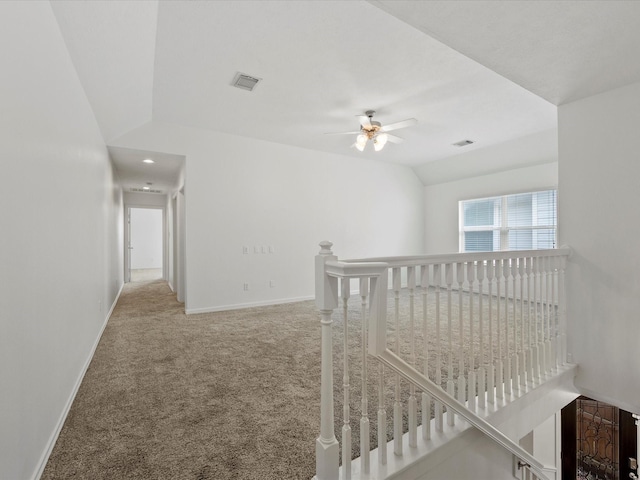 hallway featuring an upstairs landing, lofted ceiling, baseboards, carpet floors, and visible vents