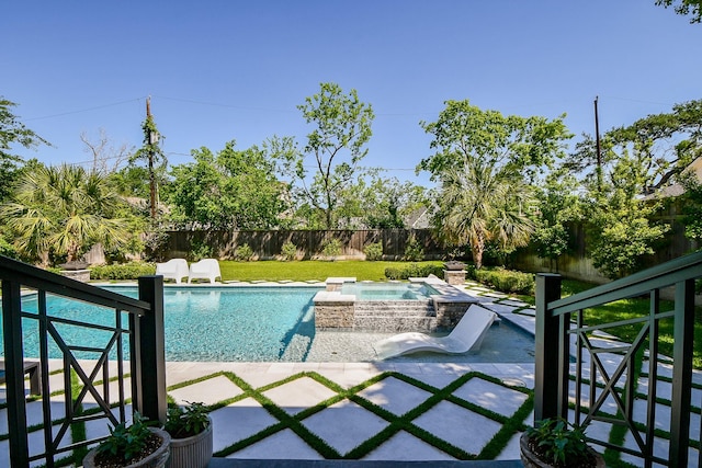 view of pool with a fenced backyard, a pool with connected hot tub, and a patio