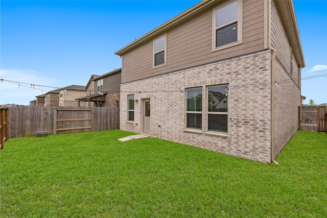1100 Greenshank Dr, Katy, TX 77493 - back of house featuring a fenced backyard, brick siding, and a yard