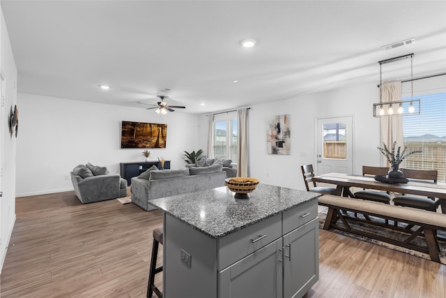 1100 Greenshank Dr, Katy, TX 77493 - kitchen with gray cabinets, visible vents, a center island, and light wood-type flooring