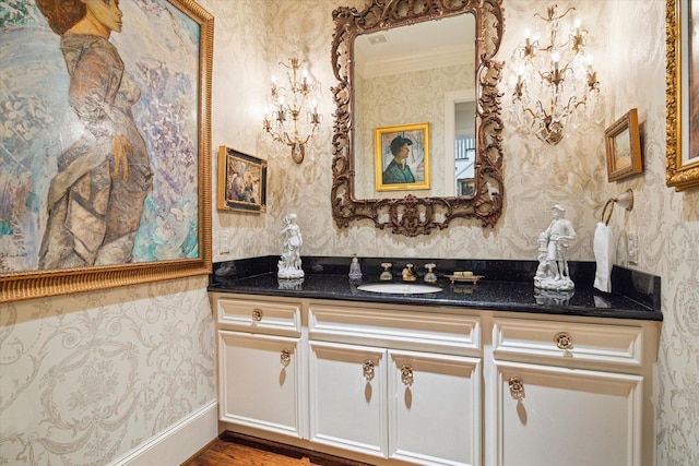 5079 Cedar Creek Dr, Houston, TX 77056 - bathroom with wallpapered walls, vanity, ornamental molding, and wood finished floors