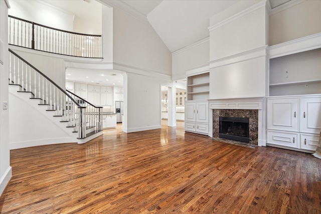 5079 Cedar Creek Dr, Houston, TX 77056 - unfurnished living room with stairs, high vaulted ceiling, baseboards, wood finished floors, and a high end fireplace