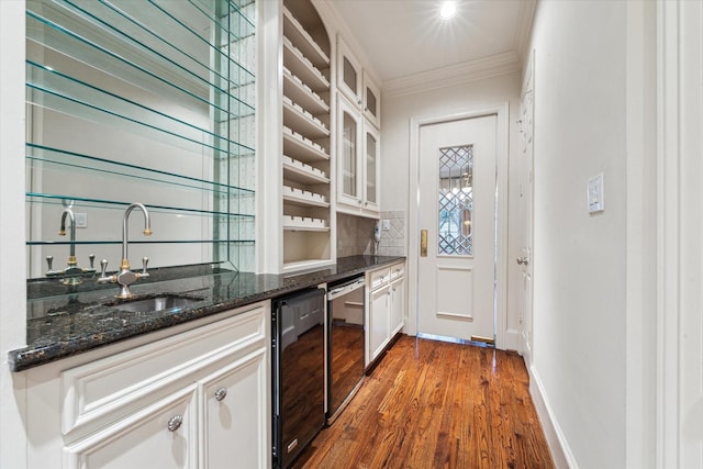 5079 Cedar Creek Dr, Houston, TX 77056 - indoor wet bar with crown molding, dark wood finished floors, wine cooler, decorative backsplash, and baseboards