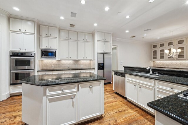 5079 Cedar Creek Dr, Houston, TX 77056 - kitchen with built in appliances, a sink, ornamental molding, a center island, and a chandelier
