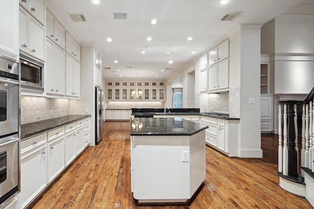 5079 Cedar Creek Dr, Houston, TX 77056 - kitchen featuring a kitchen island, backsplash, recessed lighting, white cabinetry, and light wood-style flooring