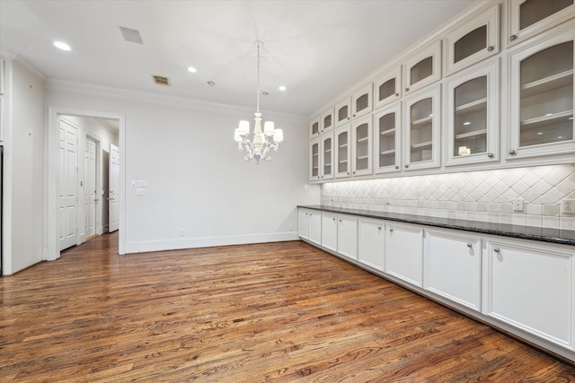 5079 Cedar Creek Dr, Houston, TX 77056 - kitchen with backsplash, a chandelier, ornamental molding, dark wood-style floors, and glass insert cabinets