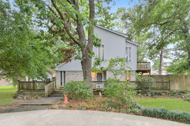 view of front of property featuring fence and a deck