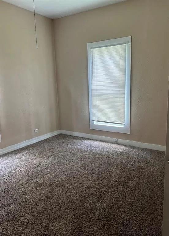405 E Main St, Bishop, TX 78343 - carpeted empty room featuring baseboards