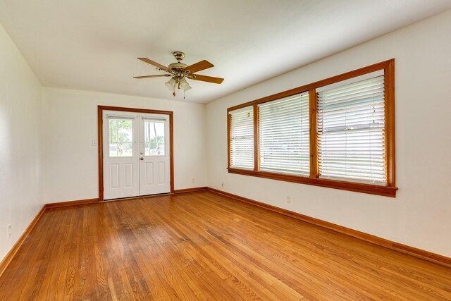 foyer entrance featuring baseboards, light wood-style floors, and a ceiling fan