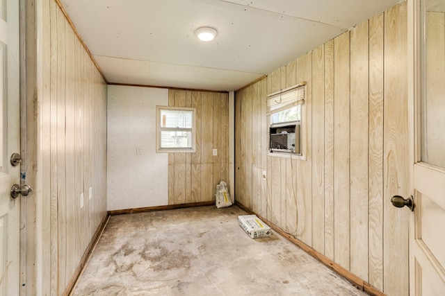 unfurnished room with cooling unit, baseboards, unfinished concrete flooring, and wooden walls