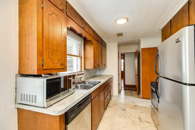 kitchen with marble finish floor, a sink, brown cabinets, and appliances with stainless steel finishes