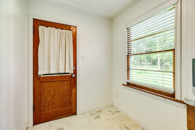 doorway to outside with marble finish floor, ornamental molding, and baseboards