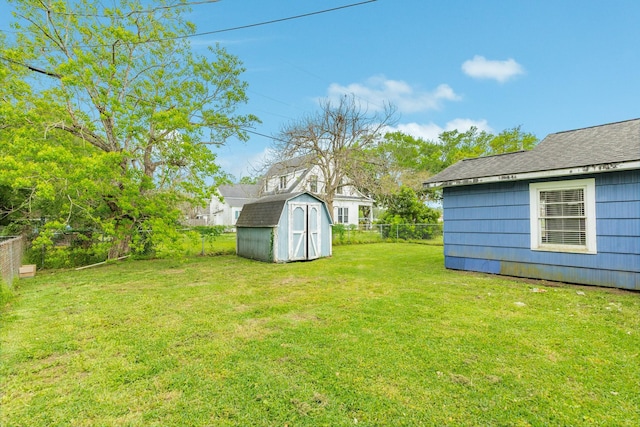 view of yard featuring an outbuilding, a shed, and fence