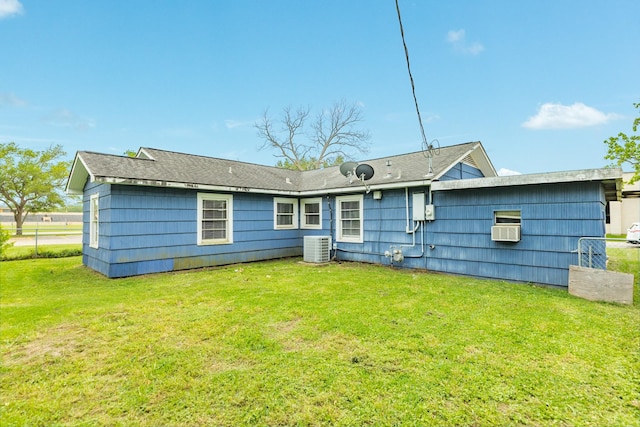 rear view of house featuring a lawn and central AC