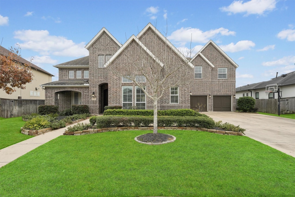2919 Sundance Summit Ln, Katy, TX 77494 - view of front facade featuring driveway, a front yard, fence, and a garage