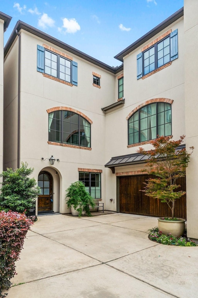 1705 Michigan St, Houston, TX 77006 - view of front of property featuring a garage, stucco siding, a standing seam roof, and driveway