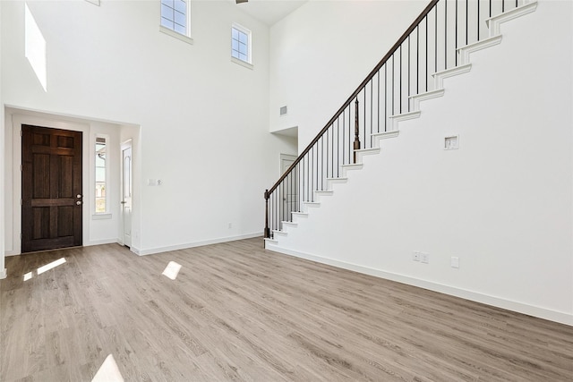 4335 Maple Root Ln, Pinehurst, TX 77362 - foyer entrance featuring a towering ceiling, wood finished floors, stairway, and baseboards