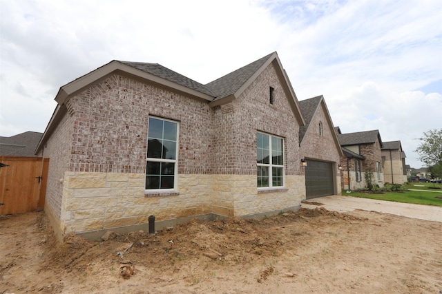 8526 Pier Cove Dr, Cypress, TX 77433 - view of side of property with brick siding, driveway, an attached garage, and a shingled roof