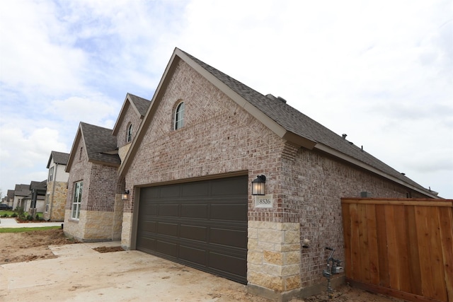 8526 Pier Cove Dr, Cypress, TX 77433 - view of side of property with roof with shingles, brick siding, a garage, and driveway