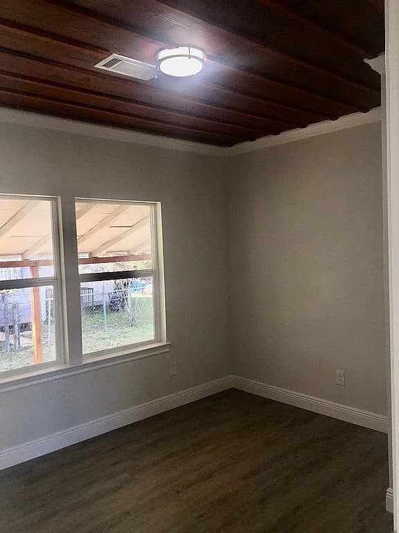 2831 Jones St, Houston, TX 77026 - empty room featuring wood ceiling, dark wood-style flooring, and crown molding